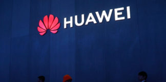 Personas caminando bajo el logo de Huawei