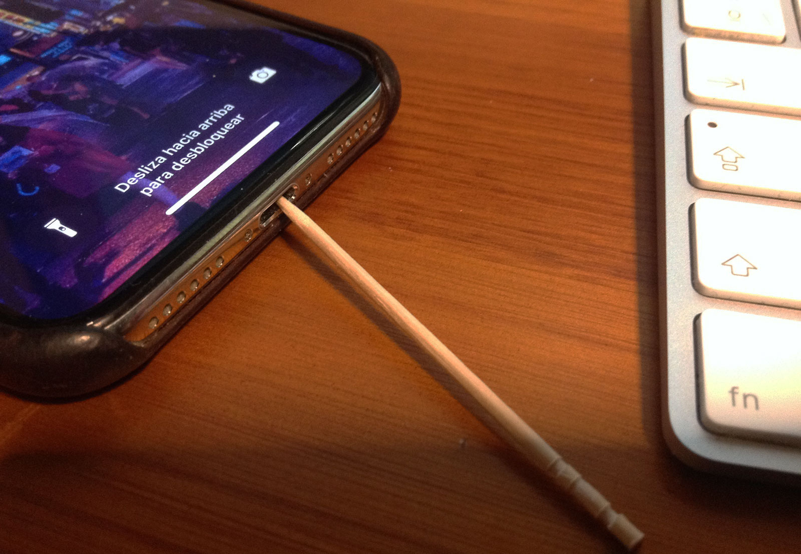 Limpiando el puerto Lightning del iPhone con un palillo de madera