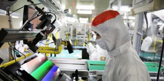 Empleado manipulando una pantalla OLED en una fábrica de Samsung Display