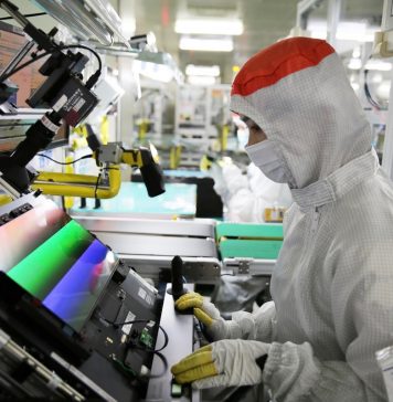 Empleado manipulando una pantalla OLED en una fábrica de Samsung Display