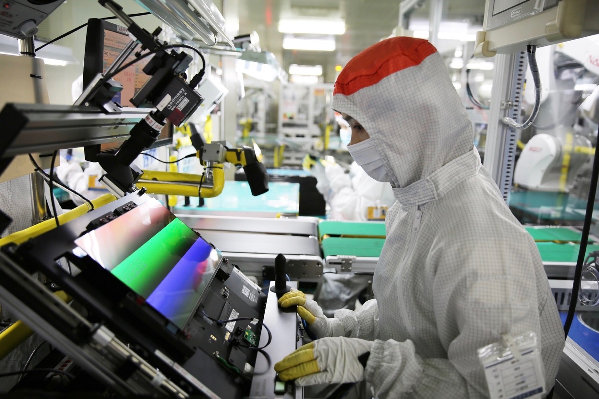 Empleado manipulando una pantalla OLED en una fábrica de Samsung Display