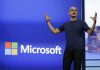 Satya Nadella delante del logo de Microsoft