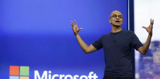 Satya Nadella delante del logo de Microsoft