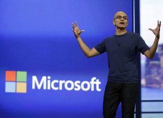 Satya Nadella delante del logo de Microsoft