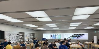 La gente haciendo cola en una Apple Store, con carteles del iPhone 17 de fondo