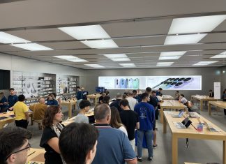La gente haciendo cola en una Apple Store, con carteles del iPhone 17 de fondo